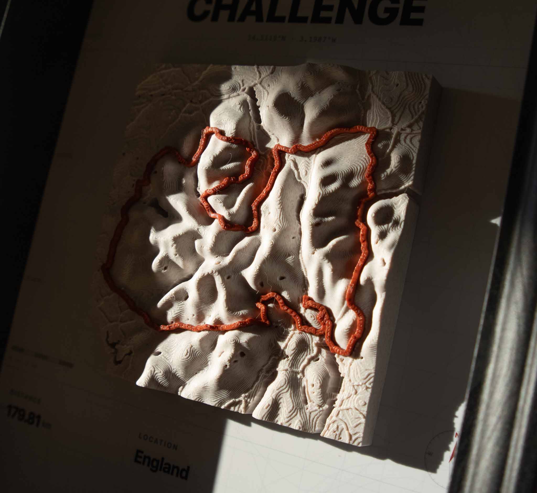 Close-up of 3D printed terrain map with the route raised in red